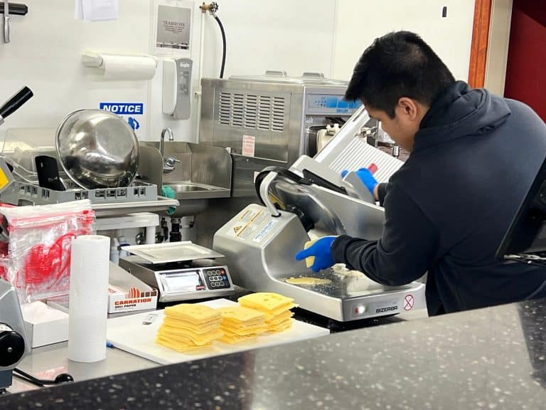 cheese being run through the slicer